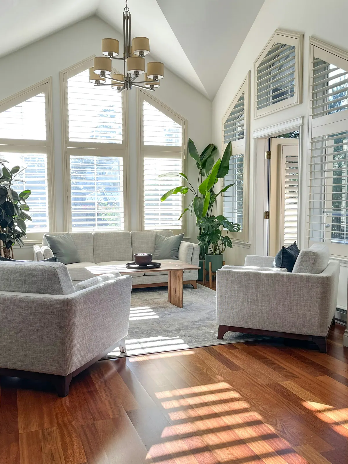 A calm, light-filled living room with soft morning sun across the floor