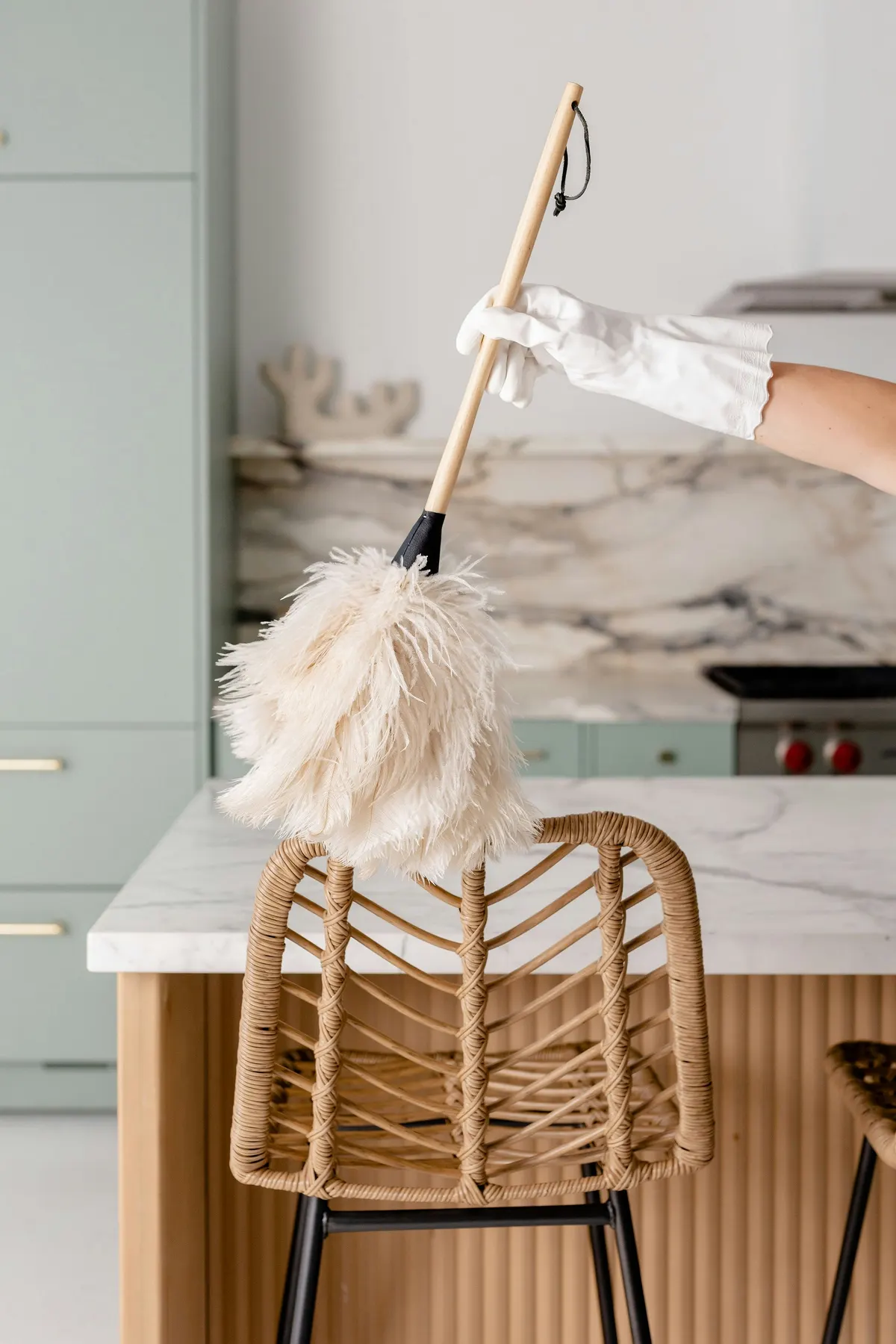 A gloved hand dusting a kitchen surface in close detail